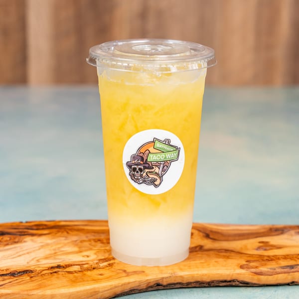 A Baymeadows Taco Way drink, yellow on top and white on bottom, on a wooden board.